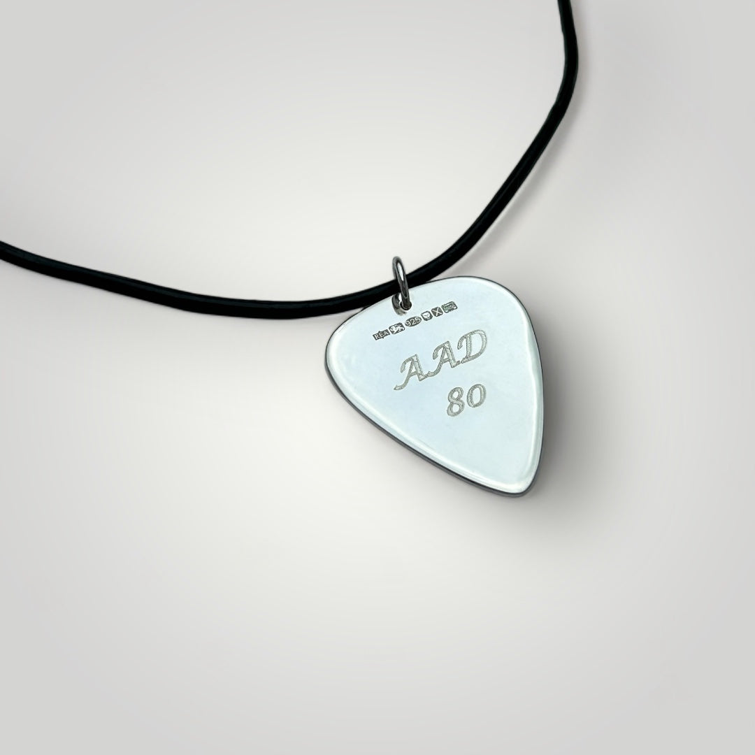 Silver guitar pick necklace on leather cord.