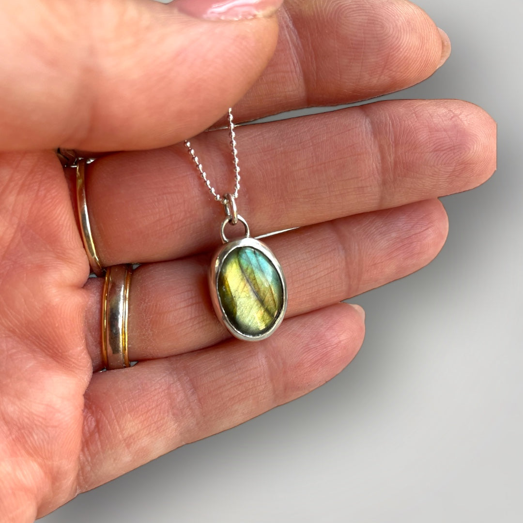 A sterling silver pendant set with an oval Labradorite on a sterling silver chain