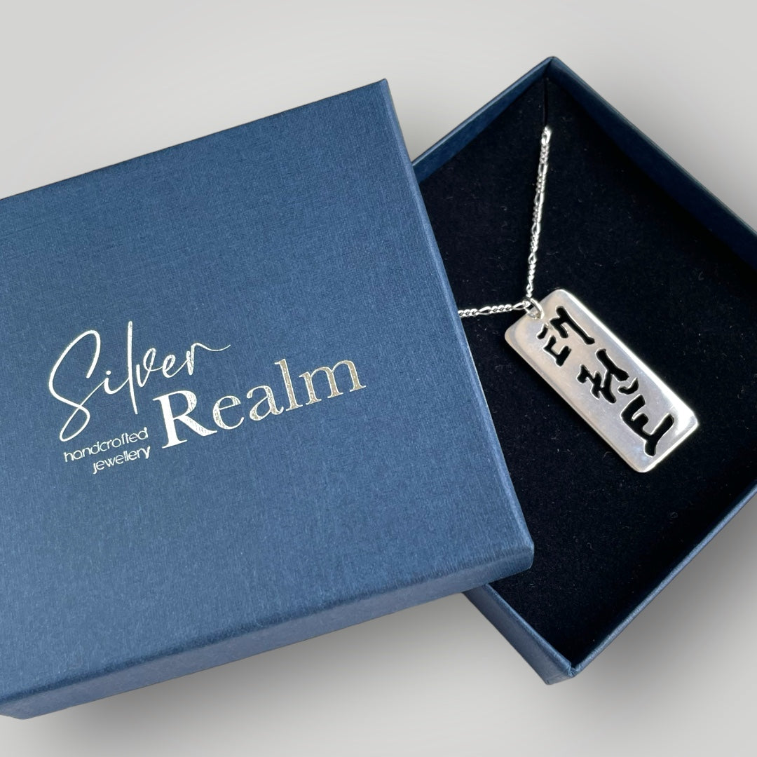 A sterling silver pendant with the script for Taekwon-Do