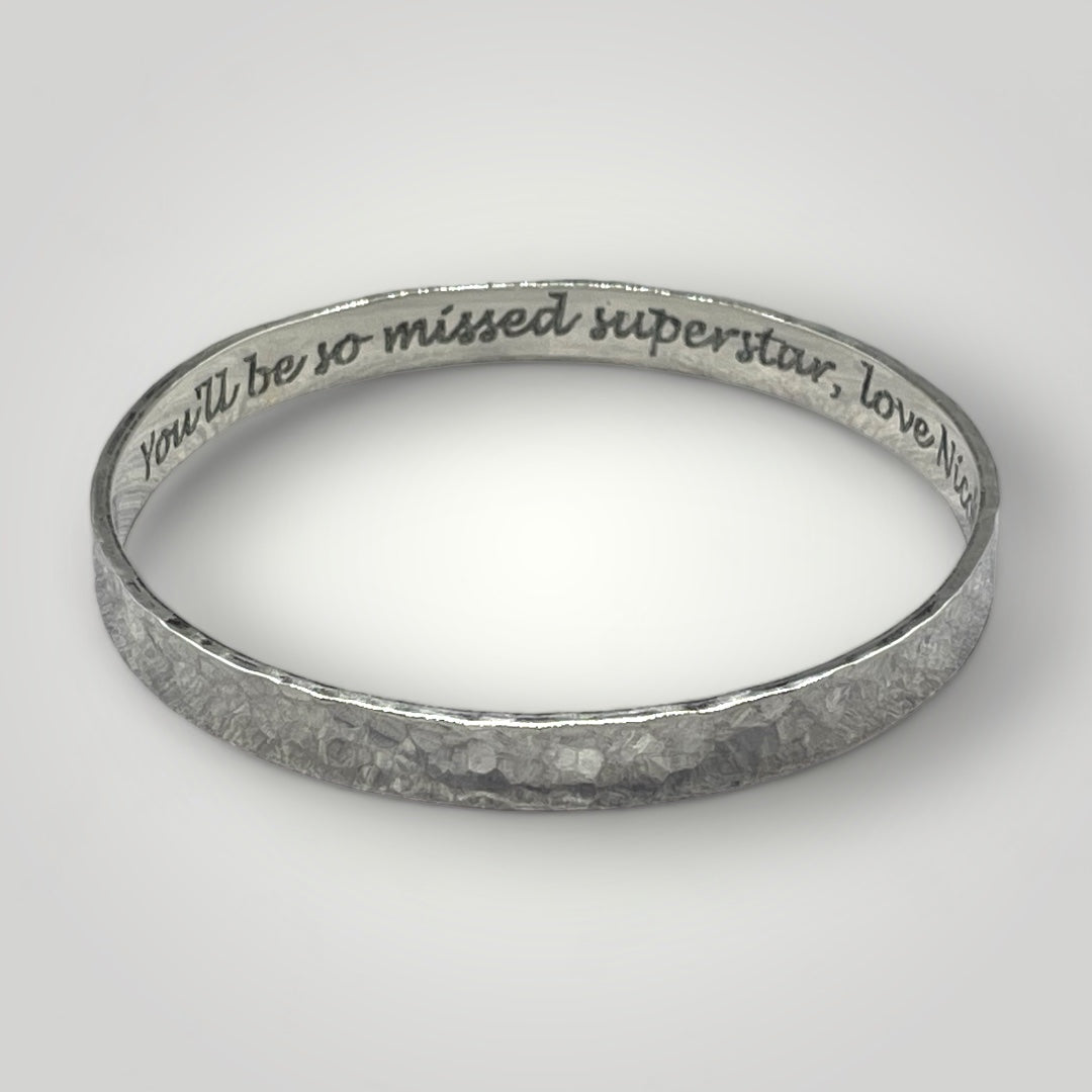 A wide sterling silver bangle with a hammered finish. Option to personalise inside of bangle with an engraved message.
