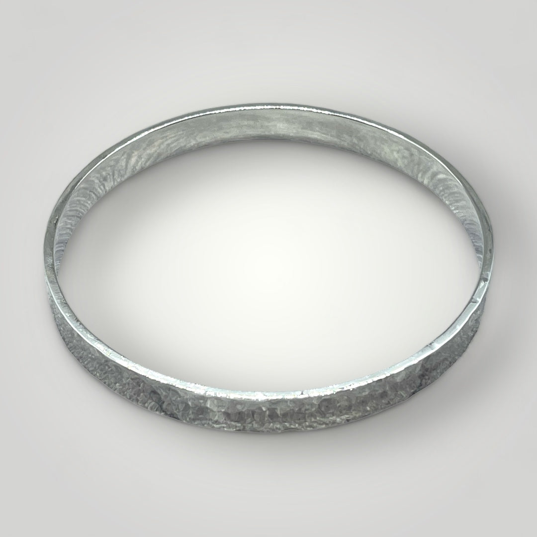 A wide sterling silver bangle with a hammered finish. Option to personalise inside of bangle with an engraved message.
