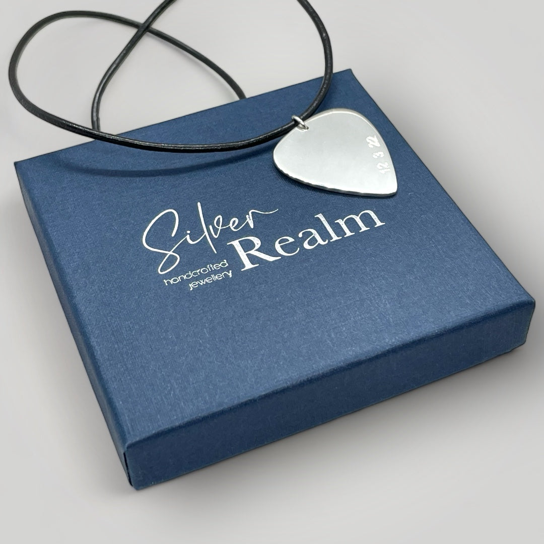 Silver guitar pick necklace on leather cord.