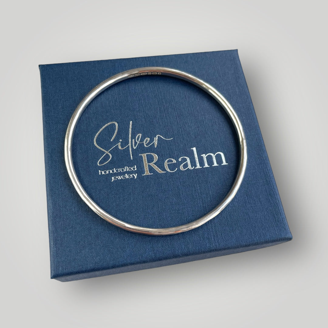 A solid sterling silver bangle with a hammered finish