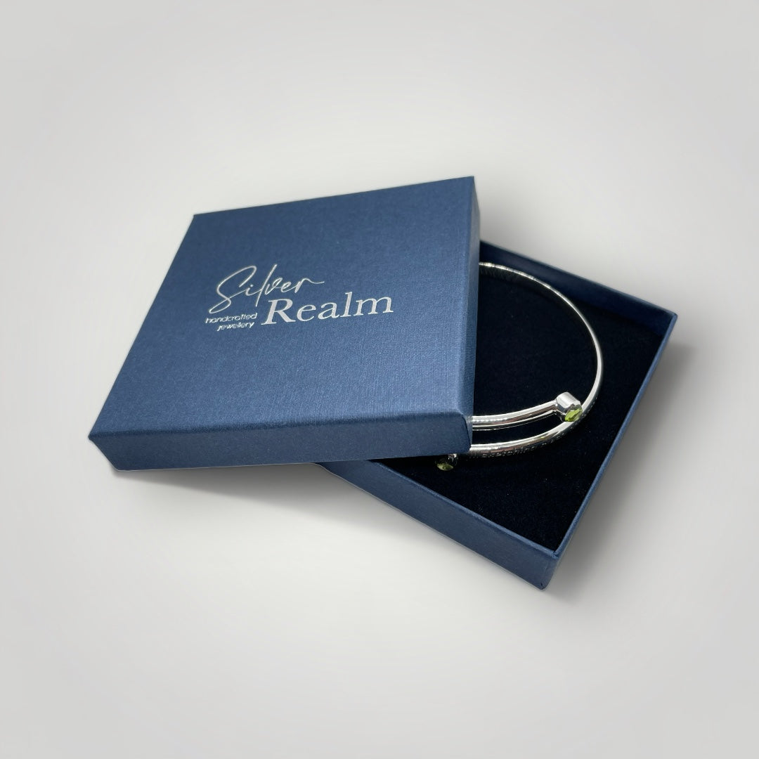 Adjustable sterling silver bangle with two Peridot and engraved with a what3words address of your choice