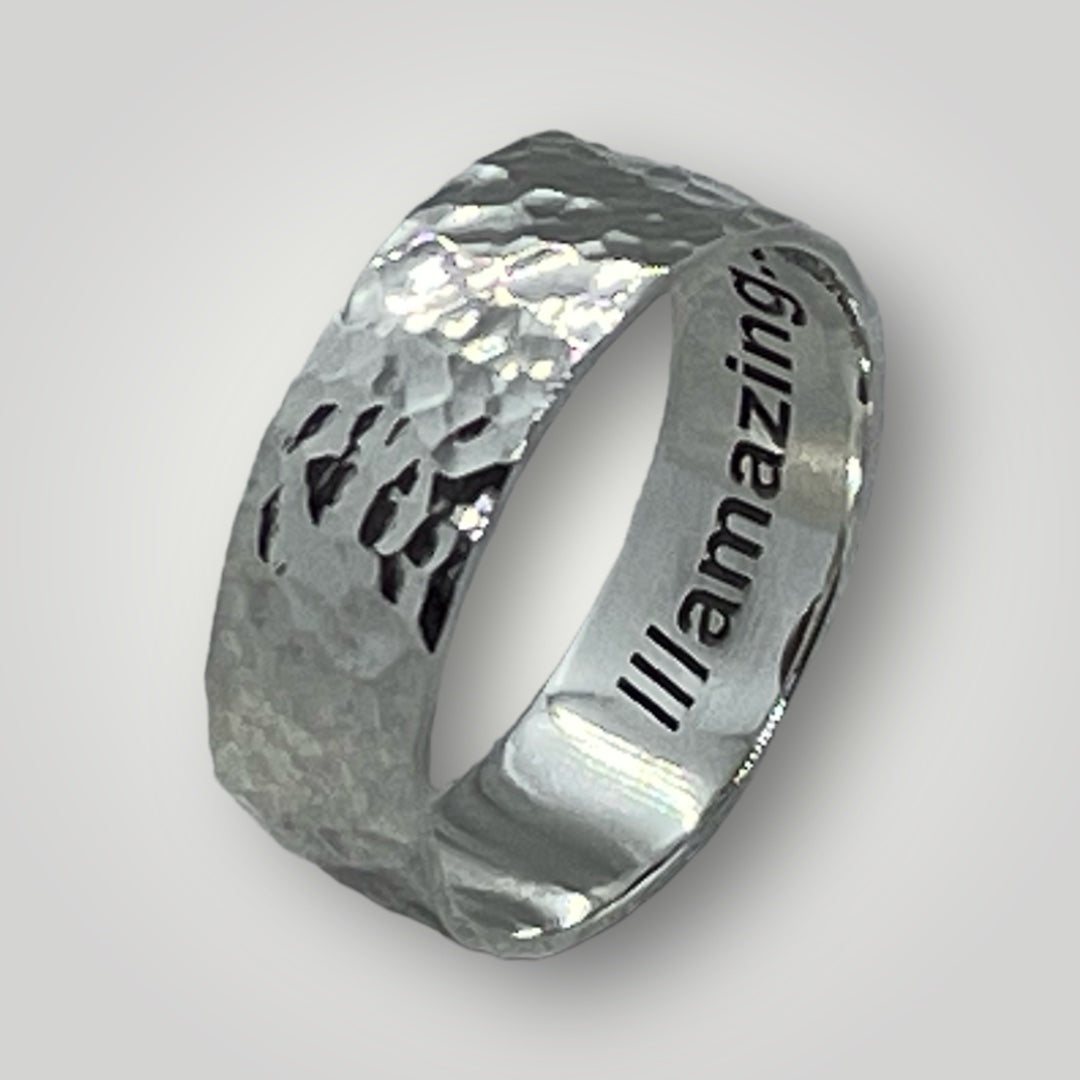 A wide, hammered, sterling silver band with your choice of what3words address laser engraved around the inside of the ring