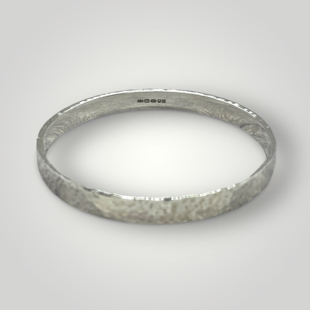 A wide sterling silver bangle with a hammered finish. Option to personalise inside of bangle with an engraved message.