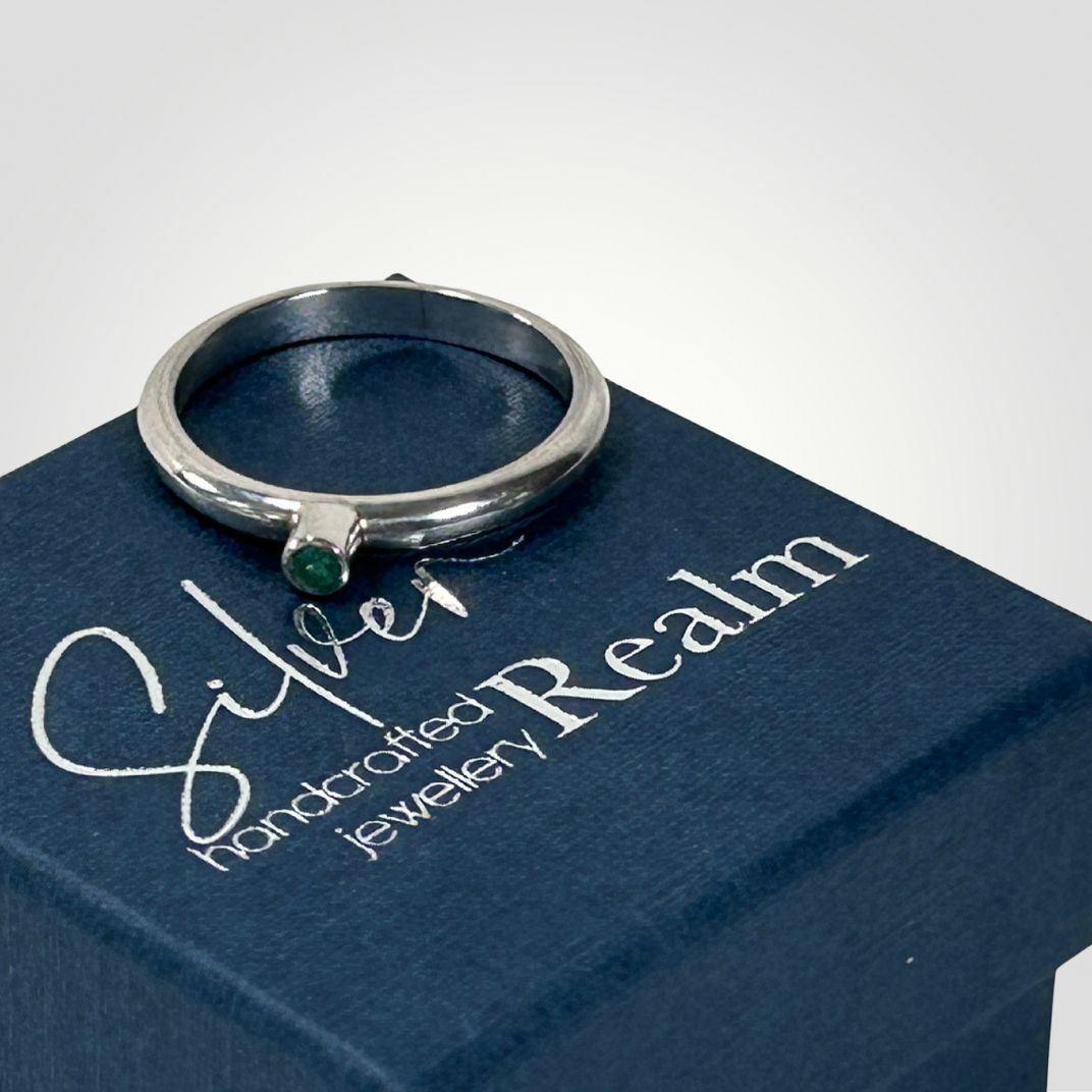 Sterling silver and Emerald stacking ring placed on top of a Silver Realm Jewellery ring box