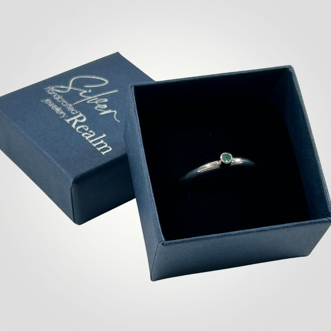 An Emerald and sterling silver stacking ring in an open, branded, gift box
