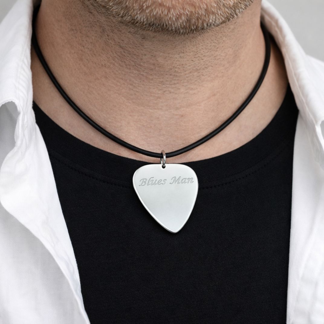 Person wearing a guitar pick pendant with 'Blues Man' engraved on the front