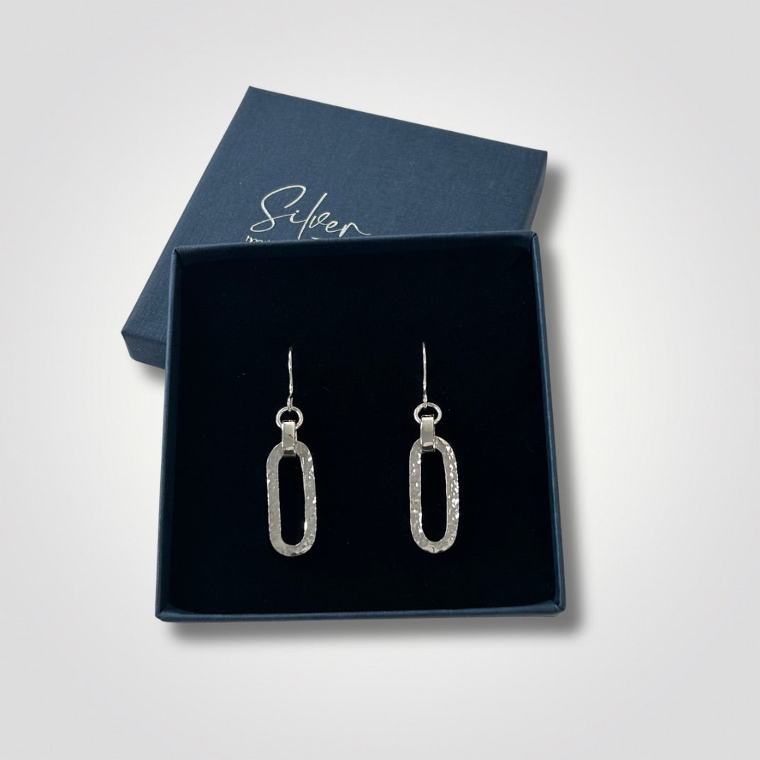 Hammered sterling silver long loop drop earrings presented in a Silver Realm gift box