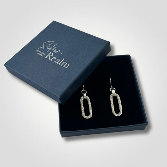 Hammered sterling silver long loop earrings presented in a Silver Realm gift box