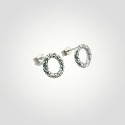 Close-up of handmade sterling silver stud earrings with twisted open circle design