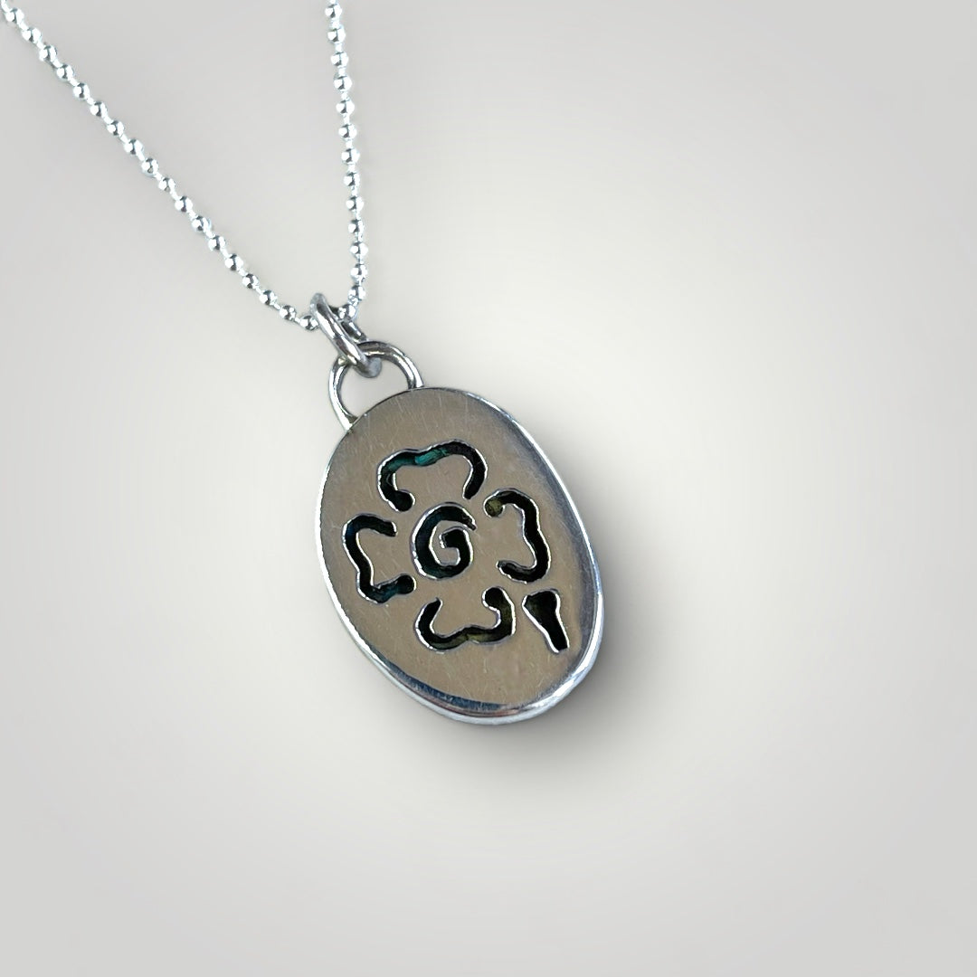 Reverse side of oval Labradorite and sterling silver pendant showing flower detail cut out. 
