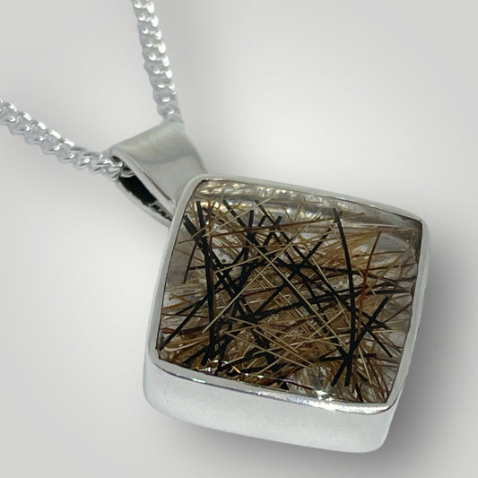 Handmade sterling silver pendant filled with resin and horse hair on a chain
