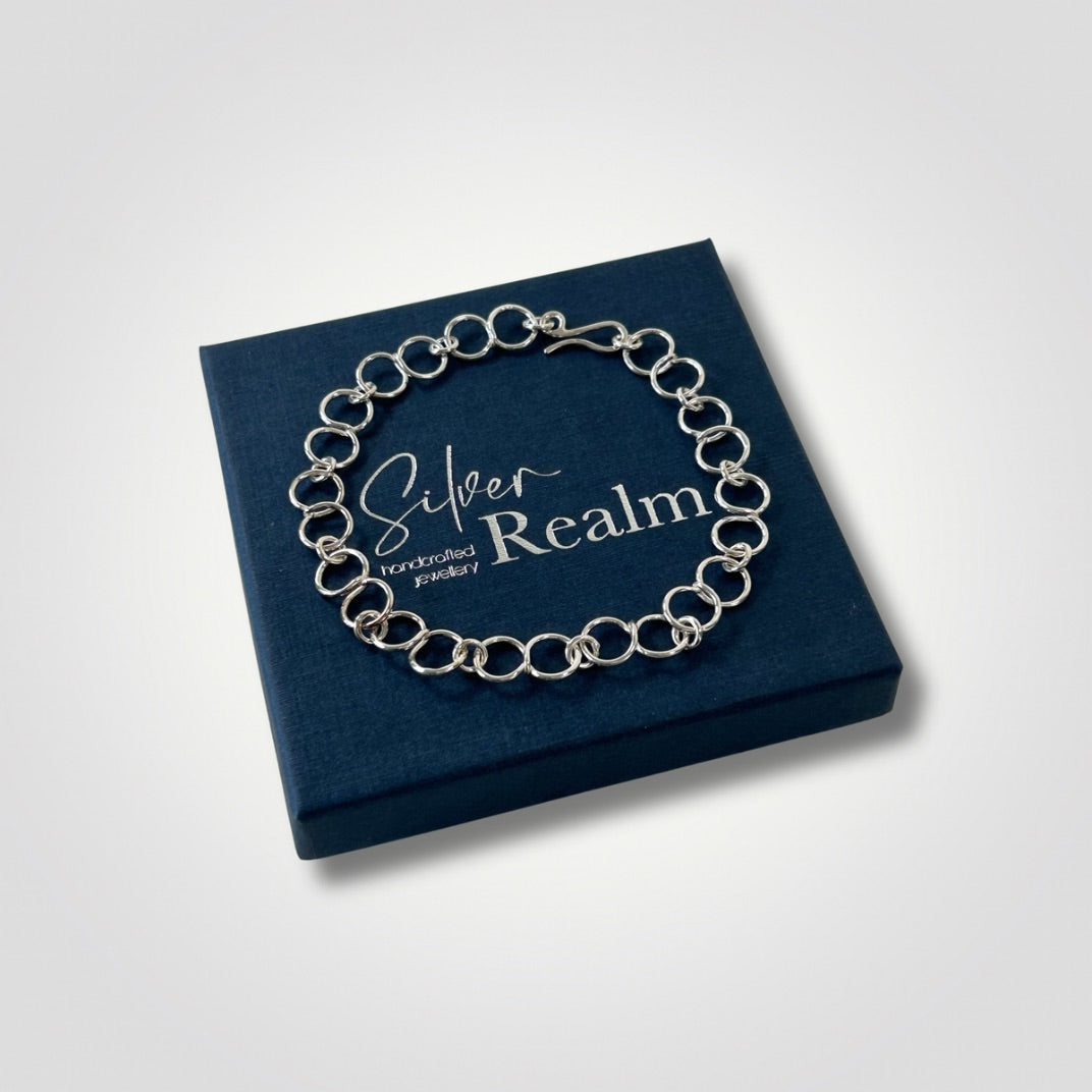Sterling silver circle link bracelet with handmade hook clasp on top of a Silver Realm branded gift box