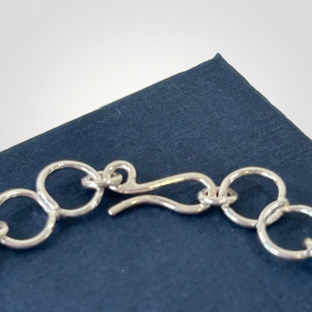 Close-up of handmade hook clasp on sterling silver circle link bracelet
Photo 4 — bracelet worn