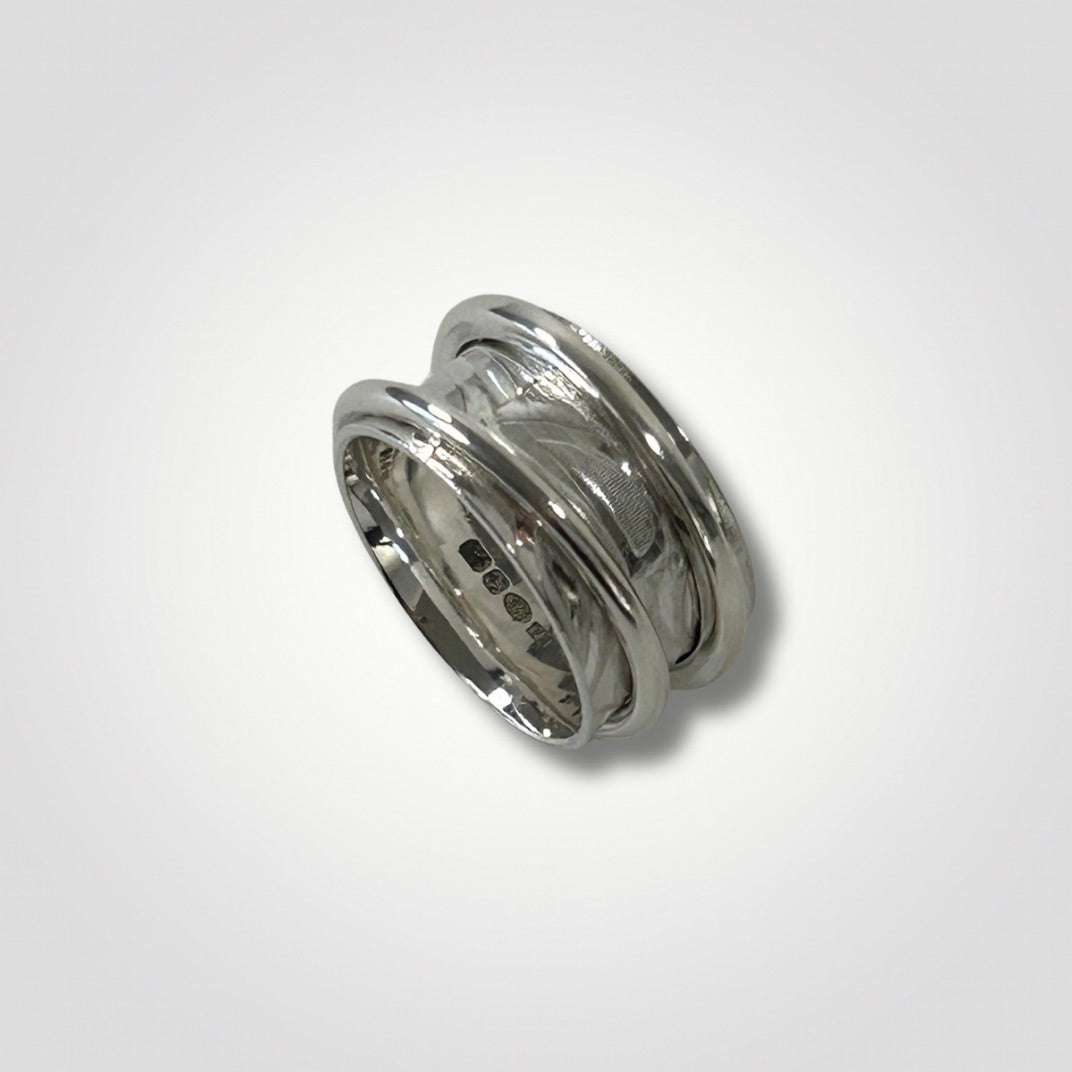 Wide textured sterling silver double spinner ring on a light grey background
