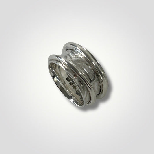 Wide textured sterling silver double spinner ring on a light grey background
