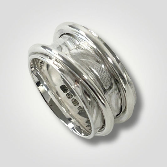 Wide textured sterling silver double spinner ring on a light grey background