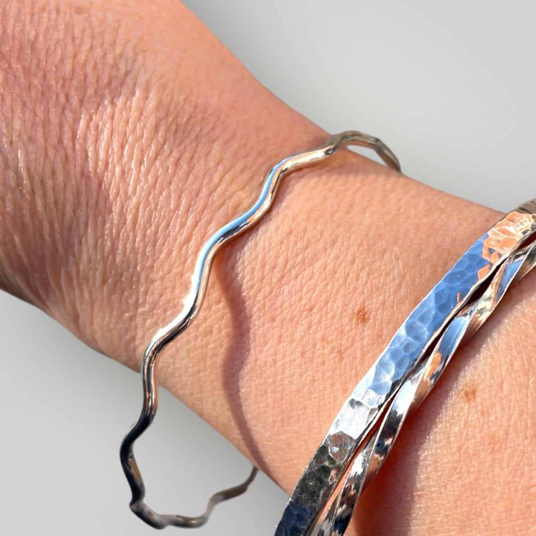 A wavy, solid, sterling silver bangle.