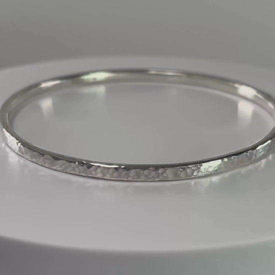 Video of a hammered sterling silver bangle on a rotating platform