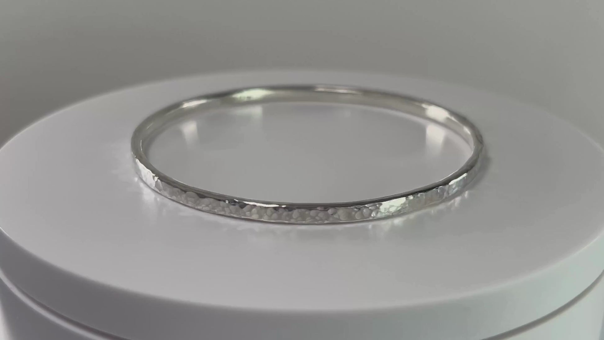 Video of a hammered sterling silver bangle on a rotating platform