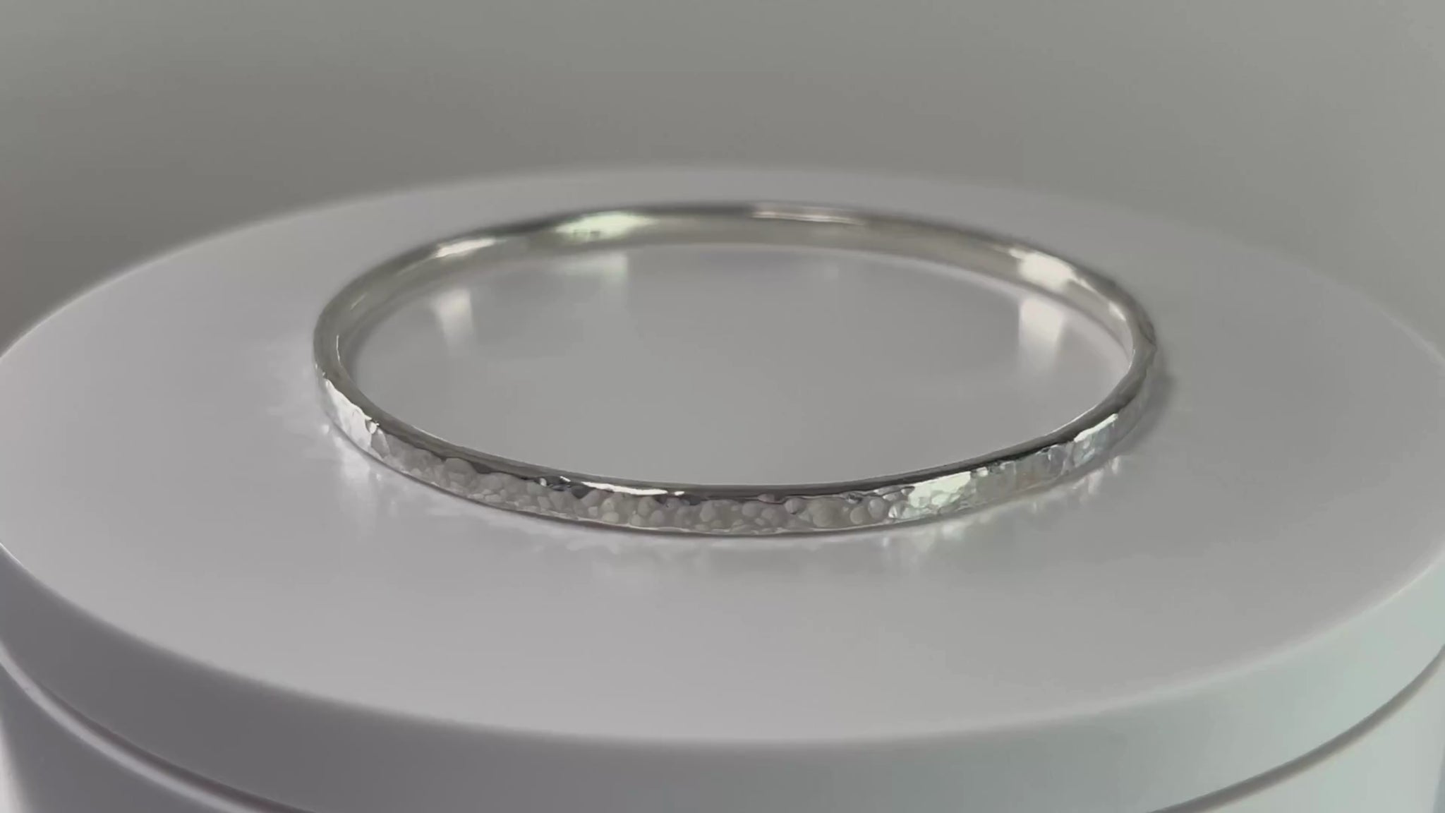Video of a hammered sterling silver bangle on a rotating platform