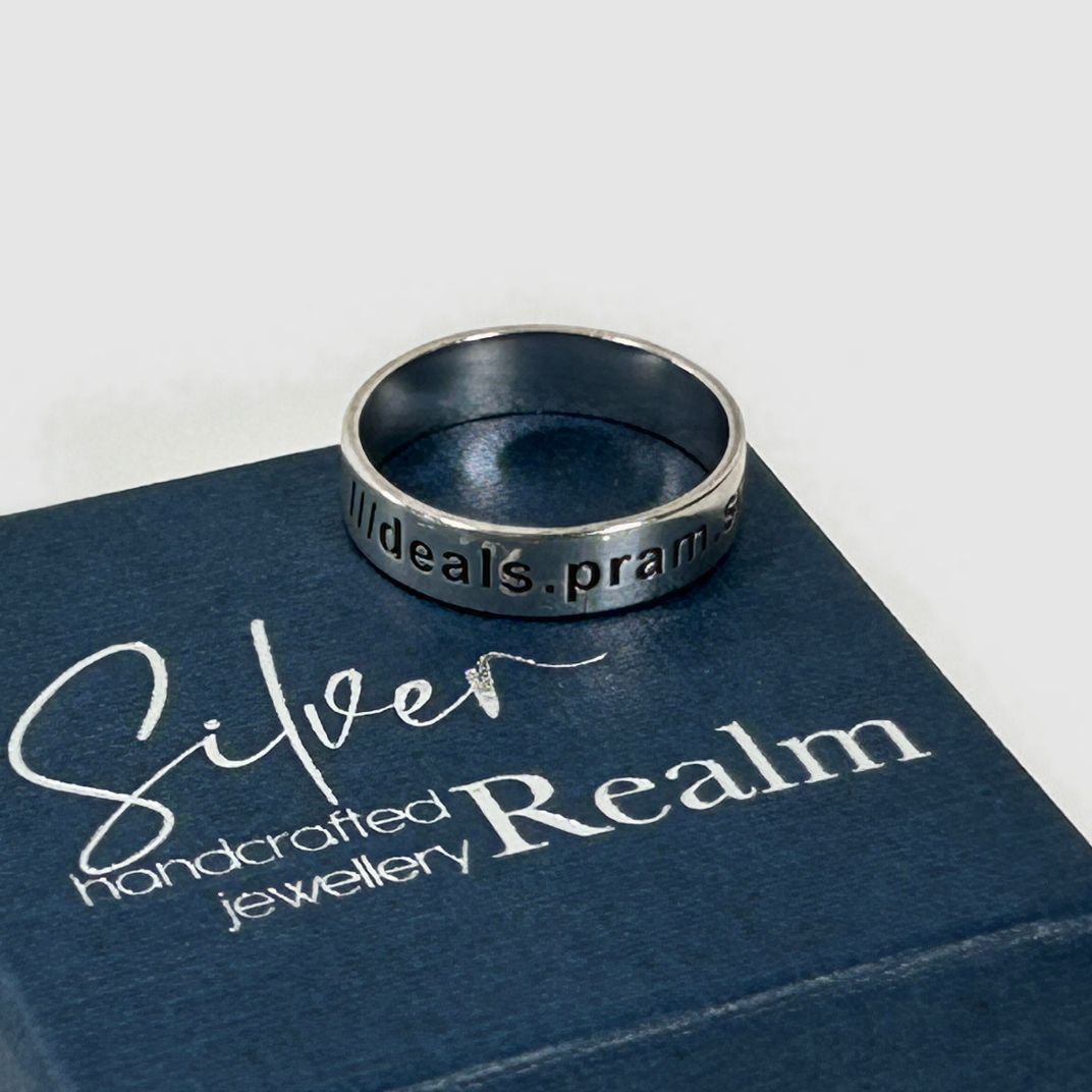 Sterling silver ring on a box with 'Silver Realm' branding